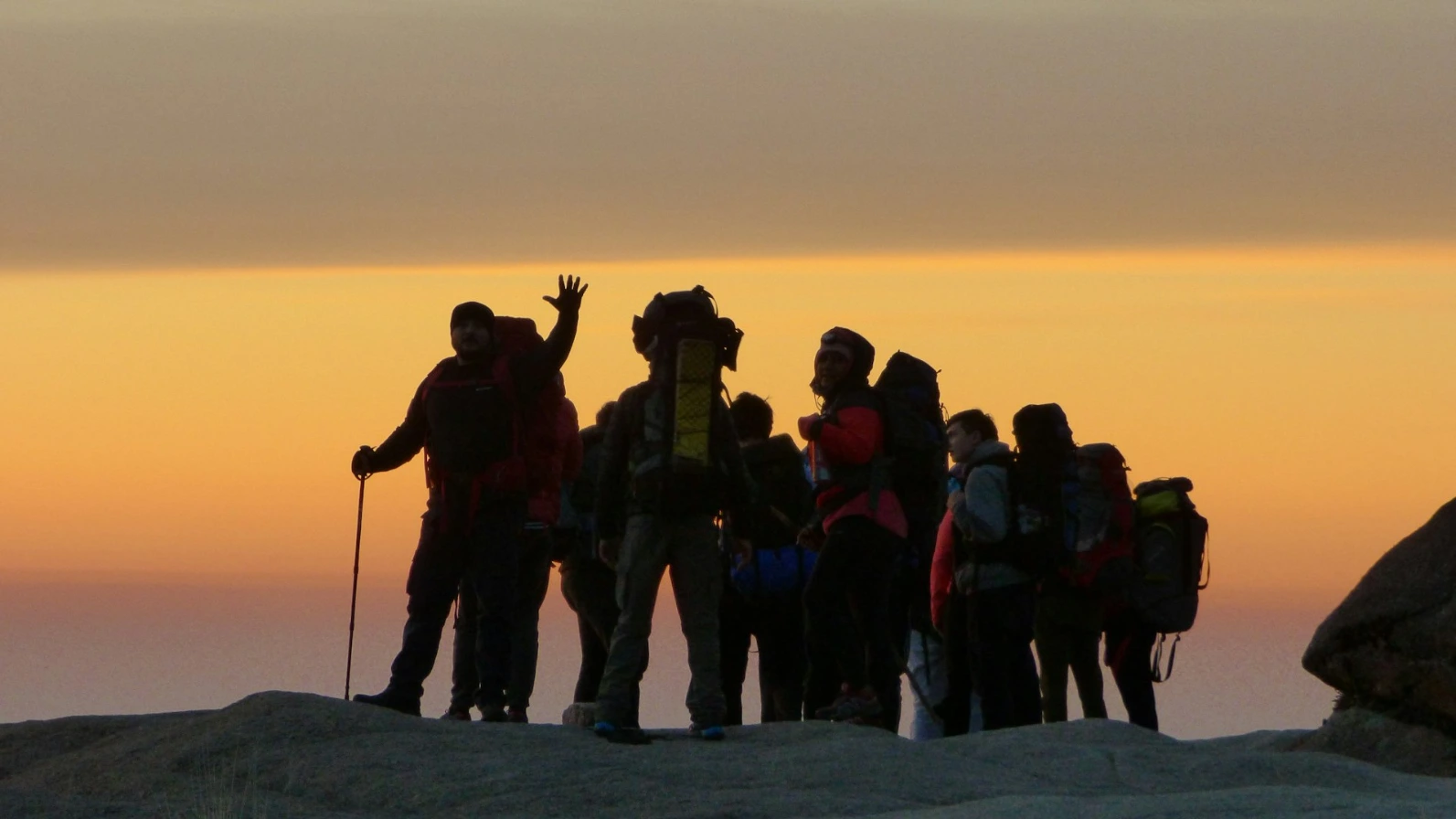 group of hikers under brown sky